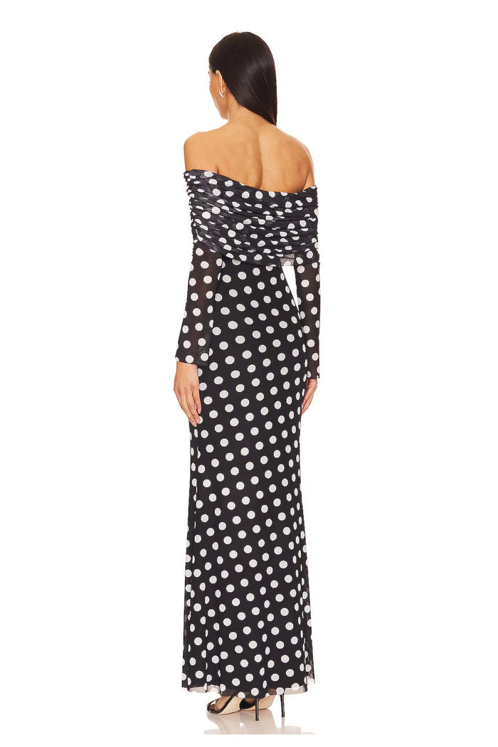 A lady showing the back of the Mama Rentals AFRM Thelma Off Shoulder Mesh Maxi Dress - Black in a studio.