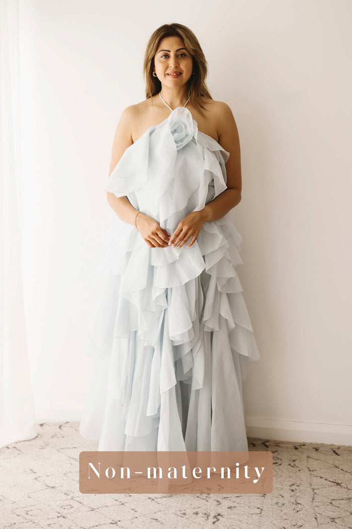 A lady wearing the Mama Rentals Aje Pandorea Layered Maxi Dress - Silver Blue in a studio.