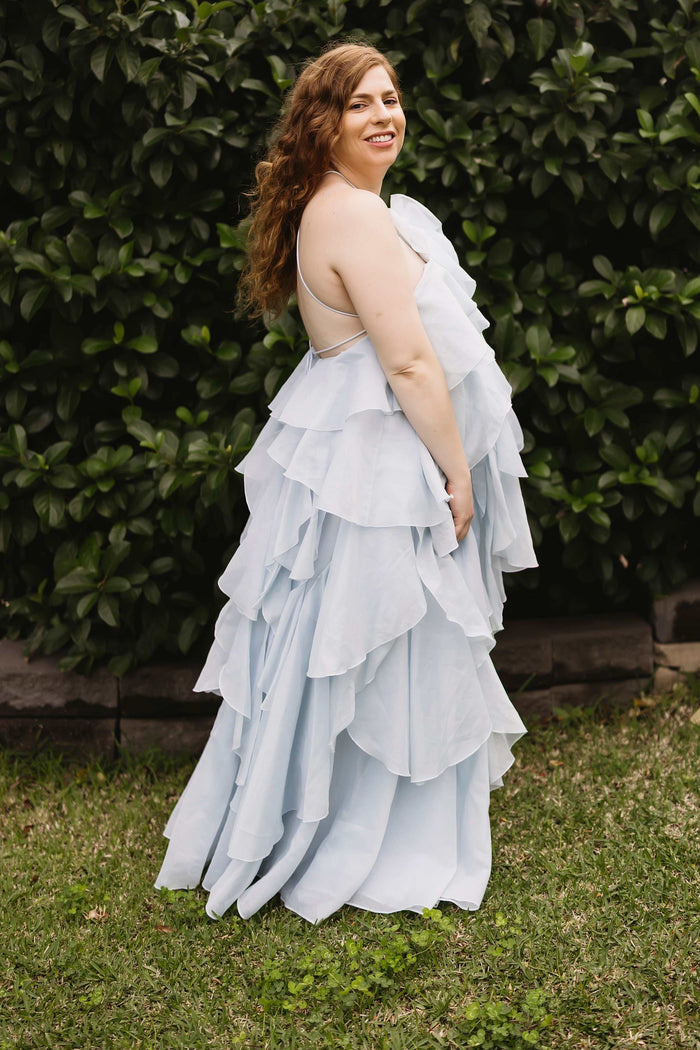 A pregnant lady wearing the Mama Rentals Aje Pandorea Layered Maxi Dress - Silver Blue side view.