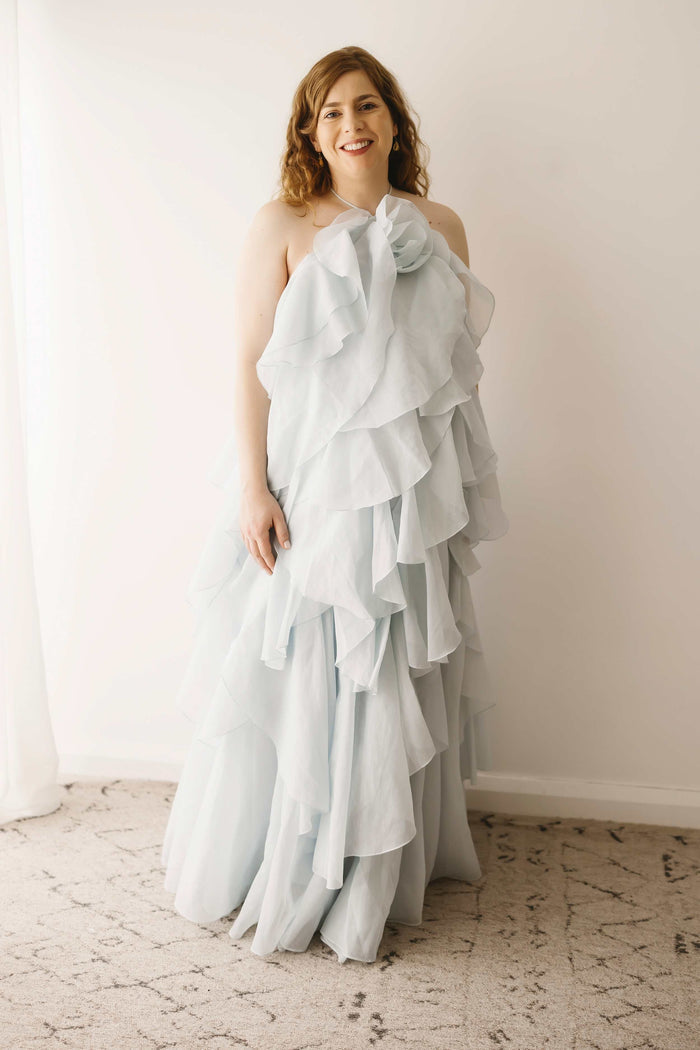 A pregnant lady wearing the Mama Rentals Aje Pandorea Layered Maxi Dress - Silver Blue in a studio.