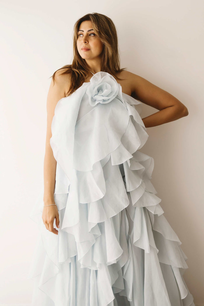 A lady wearing the Mama Rentals Aje Pandorea Layered Maxi Dress - Silver Blue in a studio.